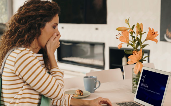 chica asustada al ver mensaje de error en su ordenador