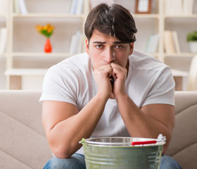 Persona preocupada con goteras en su casa