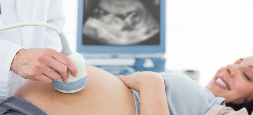 Médico haciendo una ecografía a una mujer embarazada