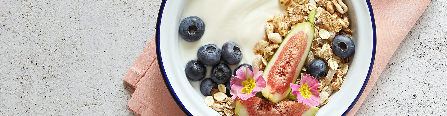 Bowl con yogurt acompañado de arándanos, higos y cereales varios