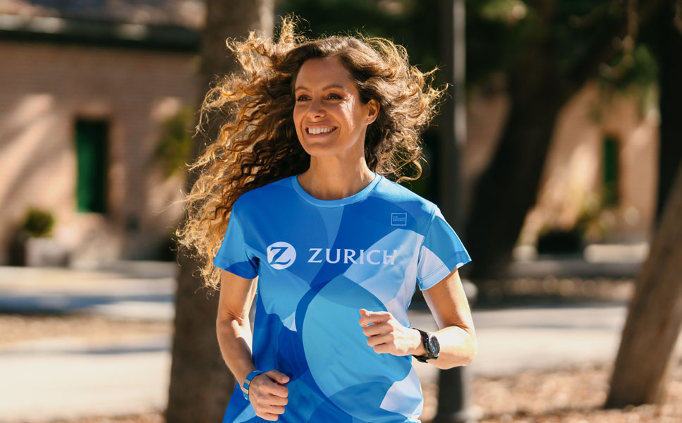 chica sonriente corriendo con una camiseta de deporte Zurich