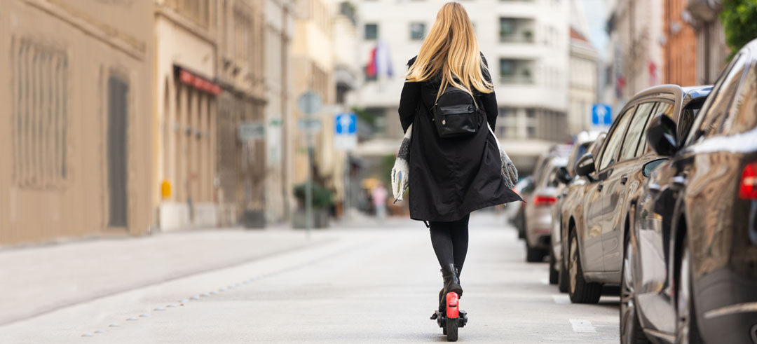 Mujer en patinete eléctrico por la calle de una ciudad